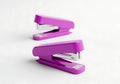 Two bright purple staplers on a clean white background Royalty Free Stock Photo