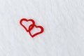 Two bright red hearts on a white blurred translucent fabric. Greeting card, background or invitation Royalty Free Stock Photo