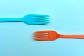 Two brightly colored forks facing towards each other on a ktchen table in retro style