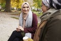 Two British Muslim Women Eating Lunch In Park Together