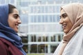 Two British Muslim Women Friends Meeting Outside Office