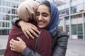 Two British Muslim Women Friends Meeting Outside Office