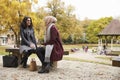 Two British Muslim Women Meeting In Urban Park