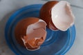 Two broken egg shells, on a blue circular container