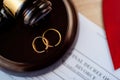 Two broken golden wedding rings on judge gavel. Royalty Free Stock Photo