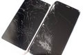 Two broken phones of white and black on a white background. cracked touchscreen glass of the touch screen isolate