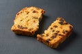 Two broken pieces of tasty sweet homemade bread with raisin lies on dark concrete table in kitchen Royalty Free Stock Photo