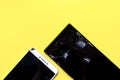 Two broken smart phones on yellow background Royalty Free Stock Photo