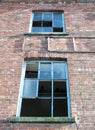 Two broken windows derelict brick building