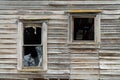 Two Broken Windows in a Dilapidated Wooden House Royalty Free Stock Photo