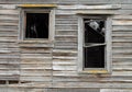 Two Broken Windows in a Dilapidated Wooden House Royalty Free Stock Photo