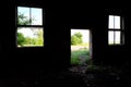 Two broken windows and an empty doorway in the wall of an abandoned building Royalty Free Stock Photo