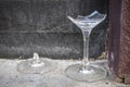 Two broken wine glasses on a background wall with old cracked plaster. Outside. Abstraction