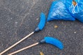 Two brooms with two full garbage bags on the road in the park close up