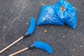 Two brooms with two full garbage bags on the road in the park