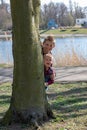 Two brother Children Hiding Behind Tree In Park
