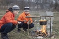 Two brother roasting hotdogs on sticks at bonfire. Children havi