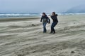 Two young men on a windy beach