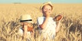 Two brothers eat black round bread on a wheat field.