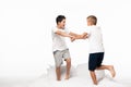 Two brothers fighting for fun white standing on bed