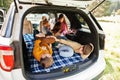 Two brothers fighting pillows at vehicle interior. Children in trunk. Traveling by car in the mountains, atmosphere concept