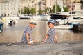 Two brothers hug and look at ships, yacht at sea Royalty Free Stock Photo