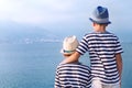 Two brothers hug and look at ships, yacht at sea Royalty Free Stock Photo