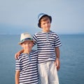 Two brothers hug and look at ships, yacht at sea Royalty Free Stock Photo