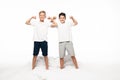 Two brothers imitating bodybuilders while standing on bed