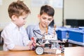 Two brothers kids playing with robot toy at school robotics class, indoor. Royalty Free Stock Photo