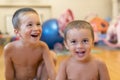 Two brothers laugh, indoor. two cheerful little boys play together, hold hands and scream on white background Royalty Free Stock Photo