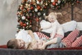 Two brothers and little sister on large bed on Christmas Eve. Children siblings are waiting for Santa Claus Royalty Free Stock Photo