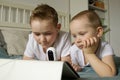 two brothers look into tablet and smartphone under the supervision of a home video camera