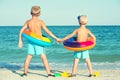 Two brothers in masks and fins are going to dive into the sea. Small divers Royalty Free Stock Photo