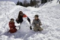 Two brothers and mother with snowman Royalty Free Stock Photo