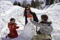 Two brothers and mother with snowman Royalty Free Stock Photo
