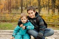 Two brothers play outdoors in autumn, best friends. Two happy boys