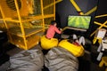 Two brothers playing football video game console, sitting on yellow pouf in kids play center Royalty Free Stock Photo