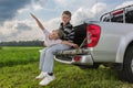 Two brothers siiting on a car trunk