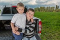 Two brothers siiting on a car trunk