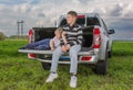 Two brothers siiting on a car trunk