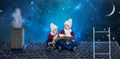 Two brothers sit on Christmas night on the roof and read a book with fairy tales.In anticipation of Christmas miracles. Royalty Free Stock Photo