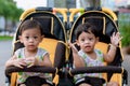 Two brothers sit in a stroller. Adorable twin baby boys sitting in stroller and smiling happily. Childhood emotions. Royalty Free Stock Photo