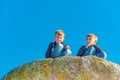 Two brothers are sitting on a cliff and looking down Royalty Free Stock Photo
