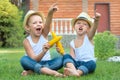 Two brothers sitting on the grass and eat corn on the cob in the garden.Fun games,laughter.