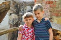 Two brothers stand near the ruined house, the concept of natural disaster, fire, and devastation. Royalty Free Stock Photo