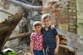 Two brothers stand near the ruined house, the concept of natural disaster, fire, and devastation.