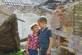 Two brothers stand near the ruined house, the concept of natural disaster, fire, and devastation. Royalty Free Stock Photo