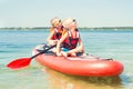 Two brothers swimming on stand up paddle board.Water sports , active lifestyle.