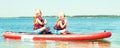 Two brothers swimming on stand up paddle board.Water sports , active lifestyle.